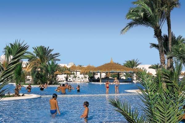 Gäste schwimmen im großen Poolbereich des Fiesta Beach Djerba Hotels.