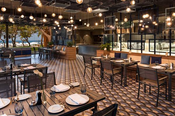 Innenbereich des Maxx Royal Kemer Resort Restaurants mit geometrischem Bodendesign und hängenden Lampen.