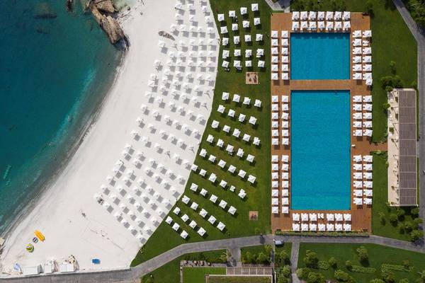 Luftaufnahme des Maxx Royal Kemer Resorts mit zwei Swimmingpools und vielen weißen Sonnenschirmen.