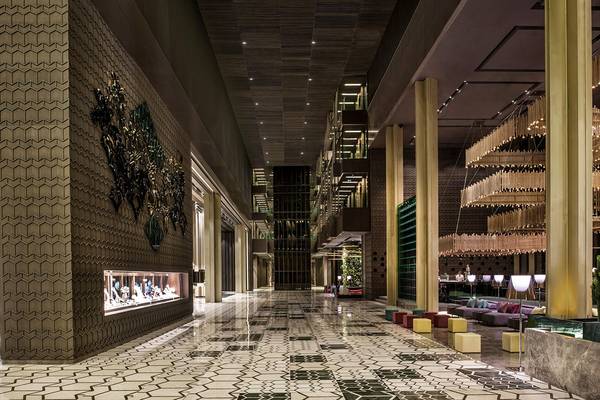 Innenbereich des Maxx Royal Kemer Resorts mit geometrischen Mustern, goldenen Säulen und Kronleuchtern.