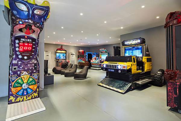 Spielzimmer im Maxx Royal Kemer Resort mit Arcade-Spielen, Sitzsäcken und einer bunten Spielhalle.