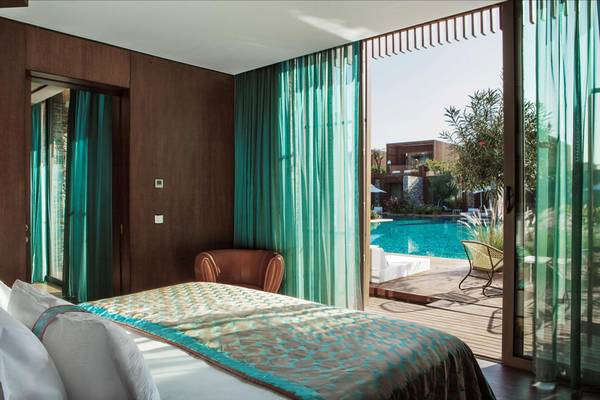 Schlafzimmer im Maxx Royal Kemer Resort mit Blick auf einen Swimmingpool und eine Terrasse.
