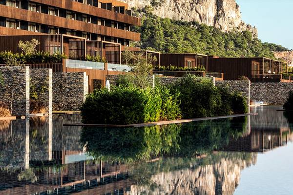 Außenansicht des Maxx Royal Kemer Resorts mit Gebäuden und einem großen Wasserbecken.