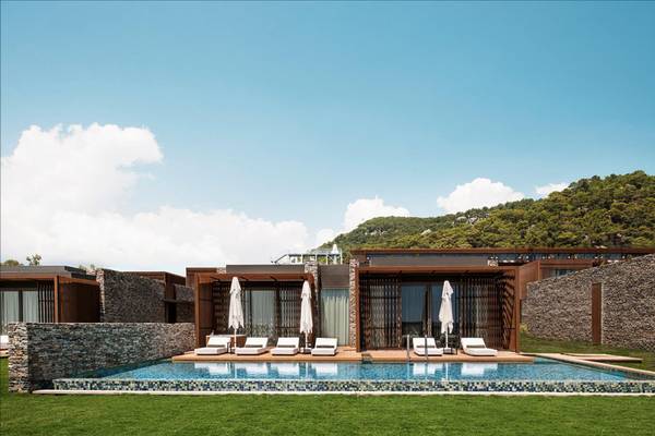 Außenbereich des Maxx Royal Kemer Resort mit Swimmingpool, Loungestühlen und Sonnenschirmen.