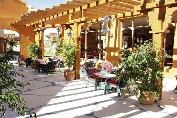 Außenbereich des Charmillion Garden Aqua Park Hotels mit Tischen, Stühlen und Pflanzen