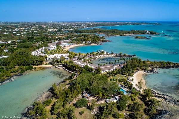 Luftaufnahme des LUX Grand Gaube Resort & Villas an der Küste mit blauem Wasser und grünen Bäumen.