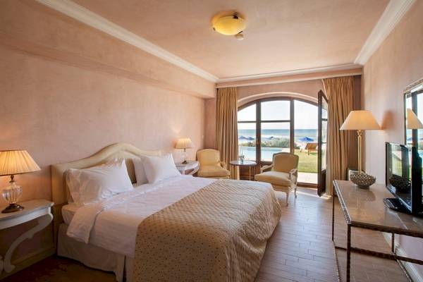Schlafzimmer im Aquila Rithymna Beach Hotel mit Blick auf das Meer und die Terrasse.