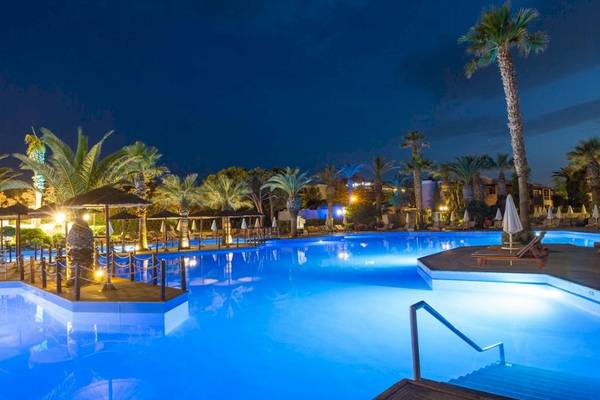 Aquila Rithymna Beach Hotel Pool bei Nacht mit blauem Wasser und Palmen