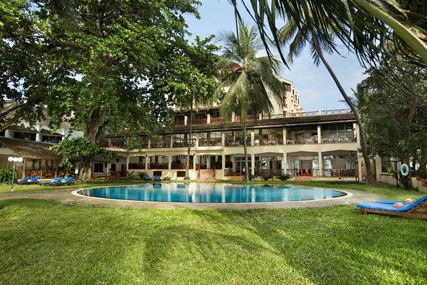 Außenansicht des Neptune Beach Resorts in Kenia mit Swimmingpool und Sonnenliegen.