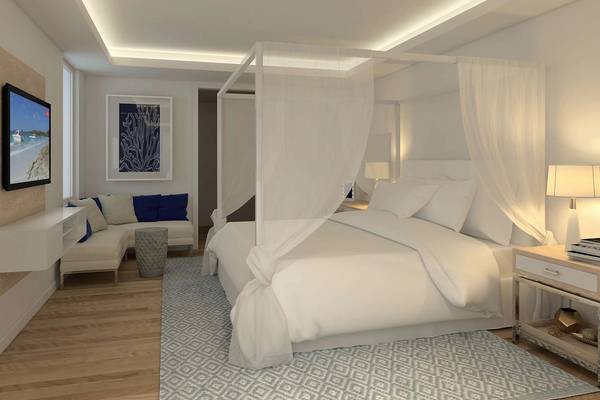 Schlafzimmer im Minos Imperial Beach Resort mit Himmelbett, weißen Vorhängen, Sofa und Fernseher.