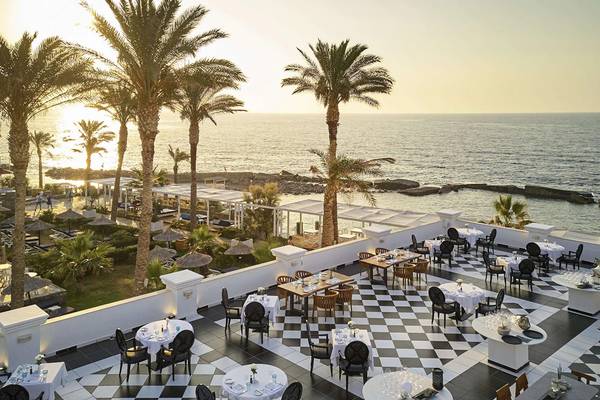 Foto der Hotelterrasse des Minos Imperial Beach Resorts mit Blick auf das Meer und Palmen