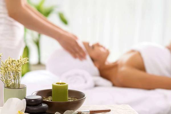 Spa-Behandlung im Minos Imperial Beach Resort mit Kerze und Blumen.