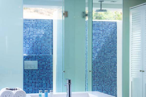 Badezimmer im Minos Imperial Beach Resort mit blauen Fliesen und Marmorarbeitsplatte.
