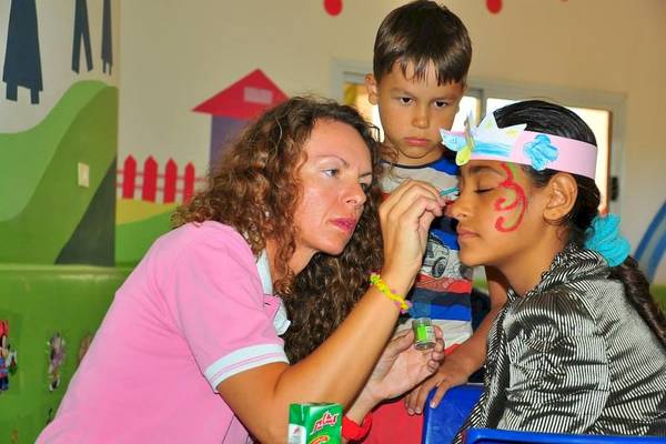 Eine Frau malt das Gesicht eines Mädchens im Kinderclub des Hurghada Long Beach Resorts.