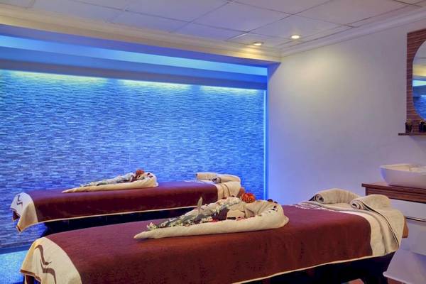 Behandlungsraum im Hurghada Long Beach Resort Spa mit zwei Massageliegen und blauer Wandbeleuchtung.