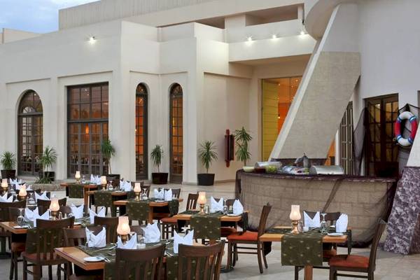 Außenbereich des Restaurants im Hurghada Long Beach Resort mit gedeckten Tischen und Stühlen.