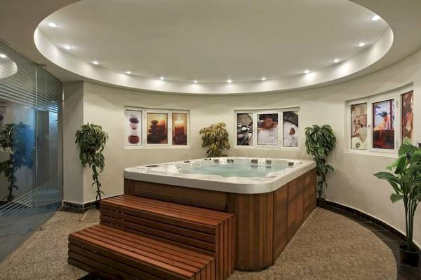 Jacuzzi im Hurghada Long Beach Resort mit Pflanzen und dekorativen Bildern an der Wand.