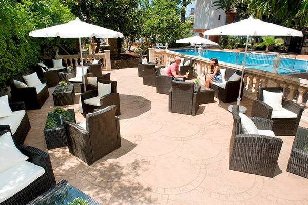 Loungebereich am Pool im HSM Venus Playa Hotel mit Paaren und Sonnenschirmen.