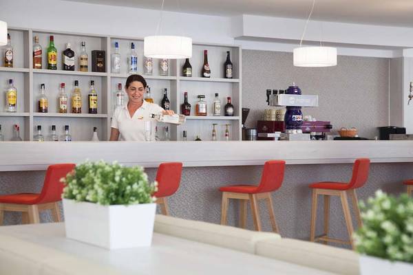 Eine Mitarbeiterin des HSM Venus Playa Hotels serviert Getränke an der Bar.