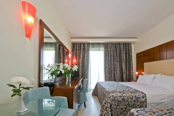 Hotelzimmer im Zante Park Resort & Spa, BW Premier Collection mit Bett, Schreibtisch und Blumen.