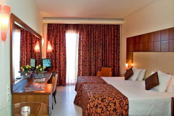 Schlafzimmer im Zante Park Resort & Spa mit zwei Betten, Schreibtisch und Blick auf ein Fenster.