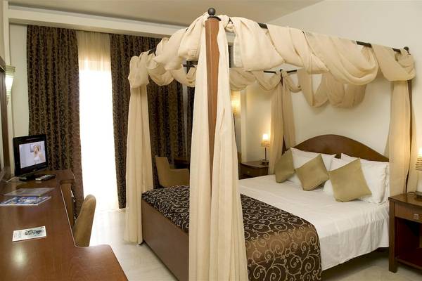 Schlafzimmer im Zante Park Resort & Spa mit Baldachin-Bett, Dekor und Möbeln.