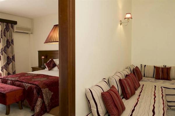 Schlafzimmer im Zante Park Resort & Spa mit Bett, Sofa, Kissen und Lampen.