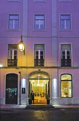 Der Eingang des Portugal Boutique Hotels bei Nacht mit einem Mann im Anzug