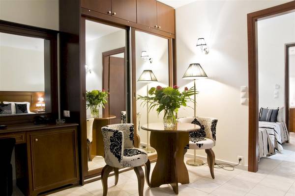 Suite Zimmer im Zante Park Resort & Spa mit Tisch, Stühlen und Blumenvase.