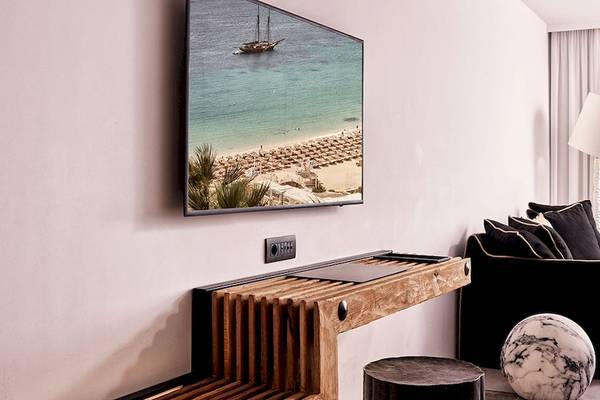 Ein Hotelzimmer mit Fernseher an der Wand und Meerblick.