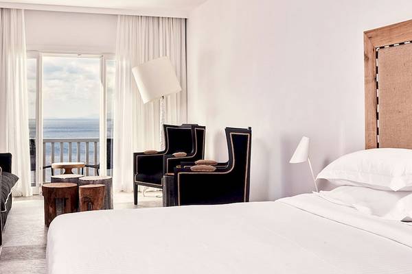 Zimmer im Royal Myconian Resort mit Blick auf das Meer und modernem Interieurdesign.