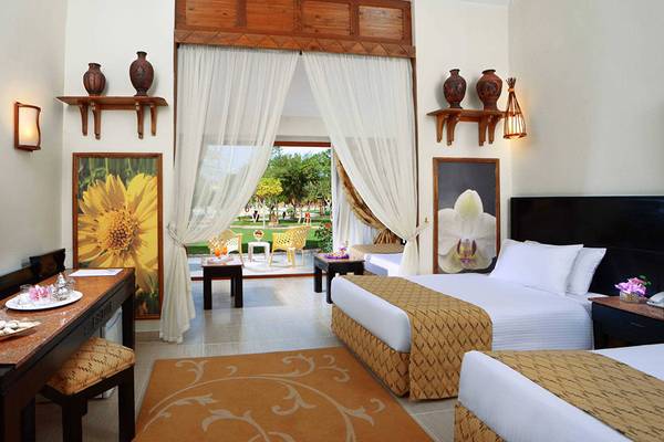 Hotelzimmer im Pickalbatros Jungle Aqua Park Resort mit Fernseher, Tisch und zwei Betten.