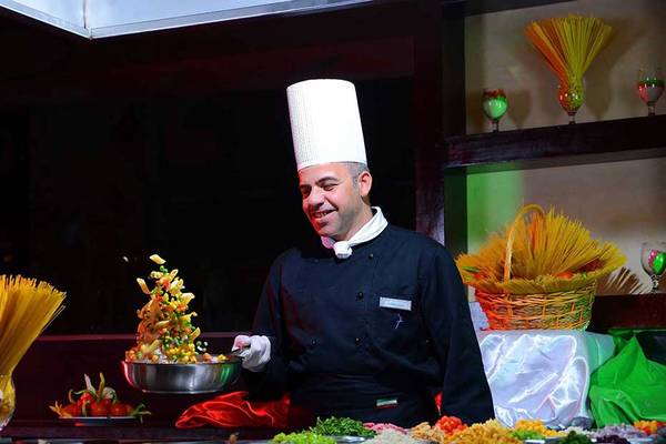 Koch beim Pickalbatros Jungle Aqua Park Resort serviert Gemüse auf einem Buffet.