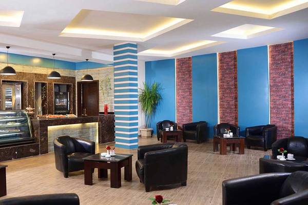 Lobby des Pickalbatros Jungle Aqua Park Resorts mit schwarzen Ledersesseln und einem blau-weiß gestreiften Design.