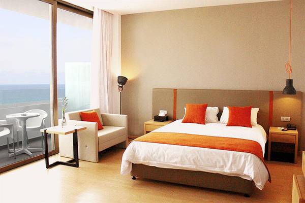 Schlafzimmer mit Meerblick im Crystal Springs Beach Hotel mit Bett, Couch und Tisch.