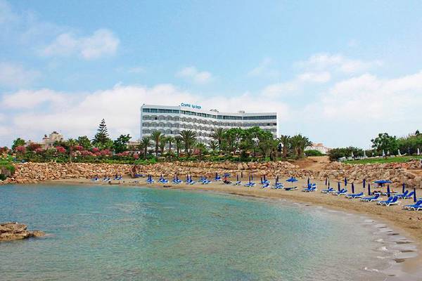 Strand mit blauen Liegen und Blick auf das Crystal Springs Beach Hotel