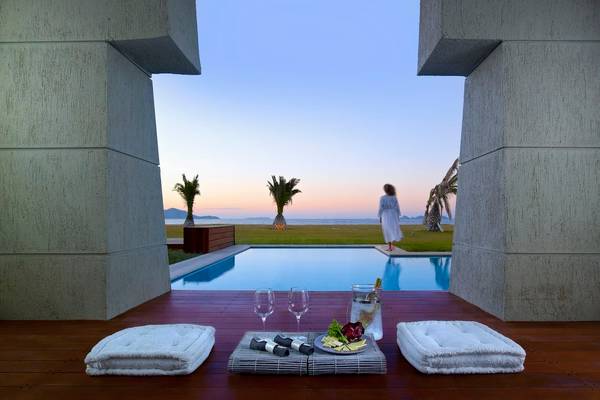 Terrasse im Astir Odysseus Kos Resort & Spa mit Blick auf den Pool und die Landschaft.