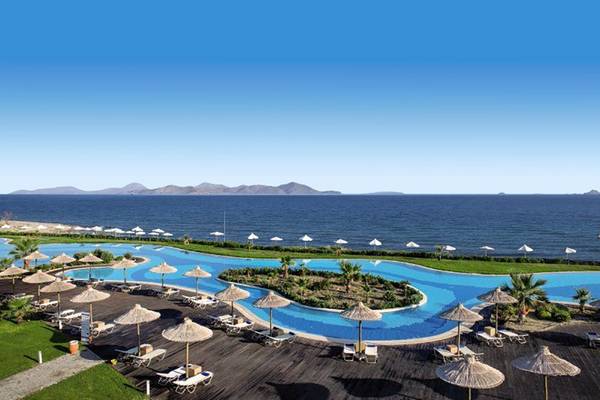 Außenbereich des Astir Odysseus Kos Resort & Spa mit großem Swimmingpool und Sonnenliegen