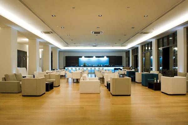 Lobby des Astir Odysseus Kos Resorts mit Lounge-Bereich und Bar.