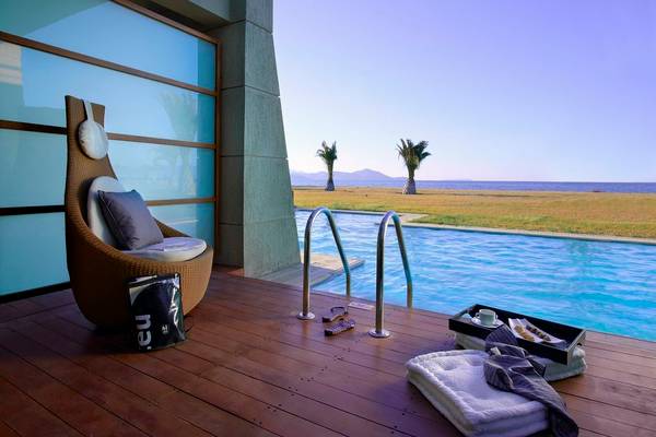 Terrasse des Astir Odysseus Kos Resorts mit Blick auf den Pool und die Landschaft.
