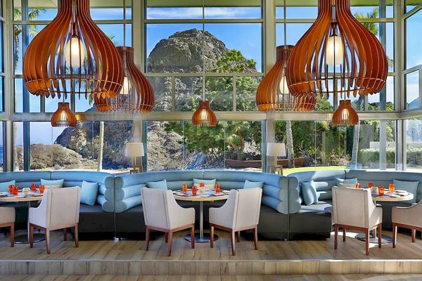 Innenraum des Al Bustan Palace, A Ritz Carlton Hotel, mit Blick auf das Meer und einen Felsen.