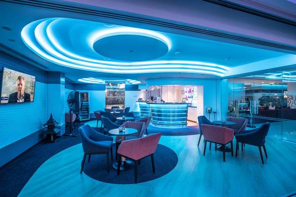 Lobby des Vassos Nissi Plage Hotels mit blauer Beleuchtung und modernen Möbeln.