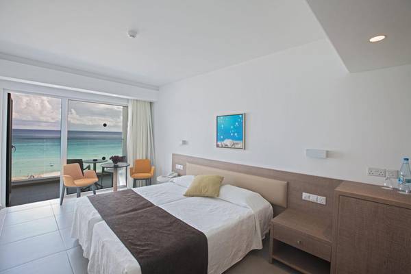 Doppelzimmer im Vassos Nissi Plage Hotel mit Meerblick, modernes Design und Balkonzugang.