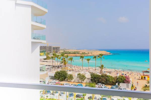 Aussicht von der Terrasse des Vassos Nissi Plage Hotels auf den Strand und das Meer.