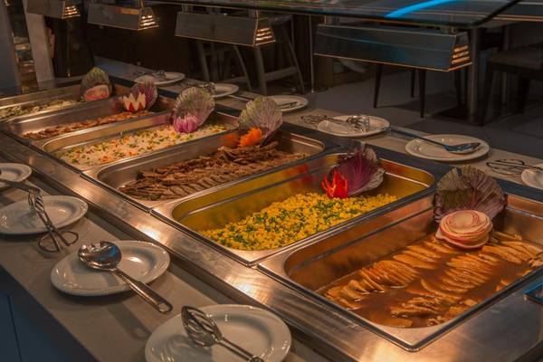 Buffet-Angebot im Vassos Nissi Plage Hotel mit verschiedenen Speisen in Silberschalen.