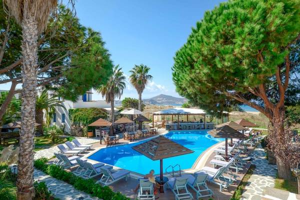 Außenbereich des Alkyoni Beach Hotels mit Swimmingpool, Sonnenliegen und Sonnenschirmen.