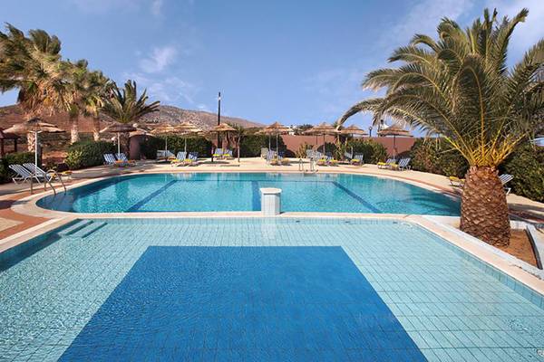 Außenpool im Blue Bay Resort mit Sonnenliegen und Palmen