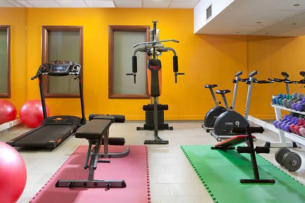 Fitnessbereich im Blue Bay Resort mit verschiedenen Geräten und Hanteln.