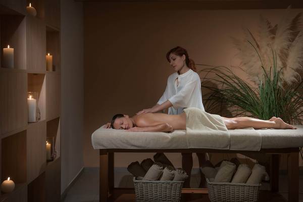 Massage im Blue Bay Resort mit Frau, die Rückenmassage gibt.