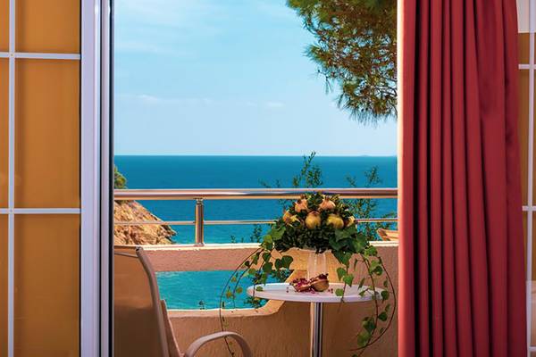 Balkonblick auf das Meer vom Blue Bay Resort mit Tisch und Blumen